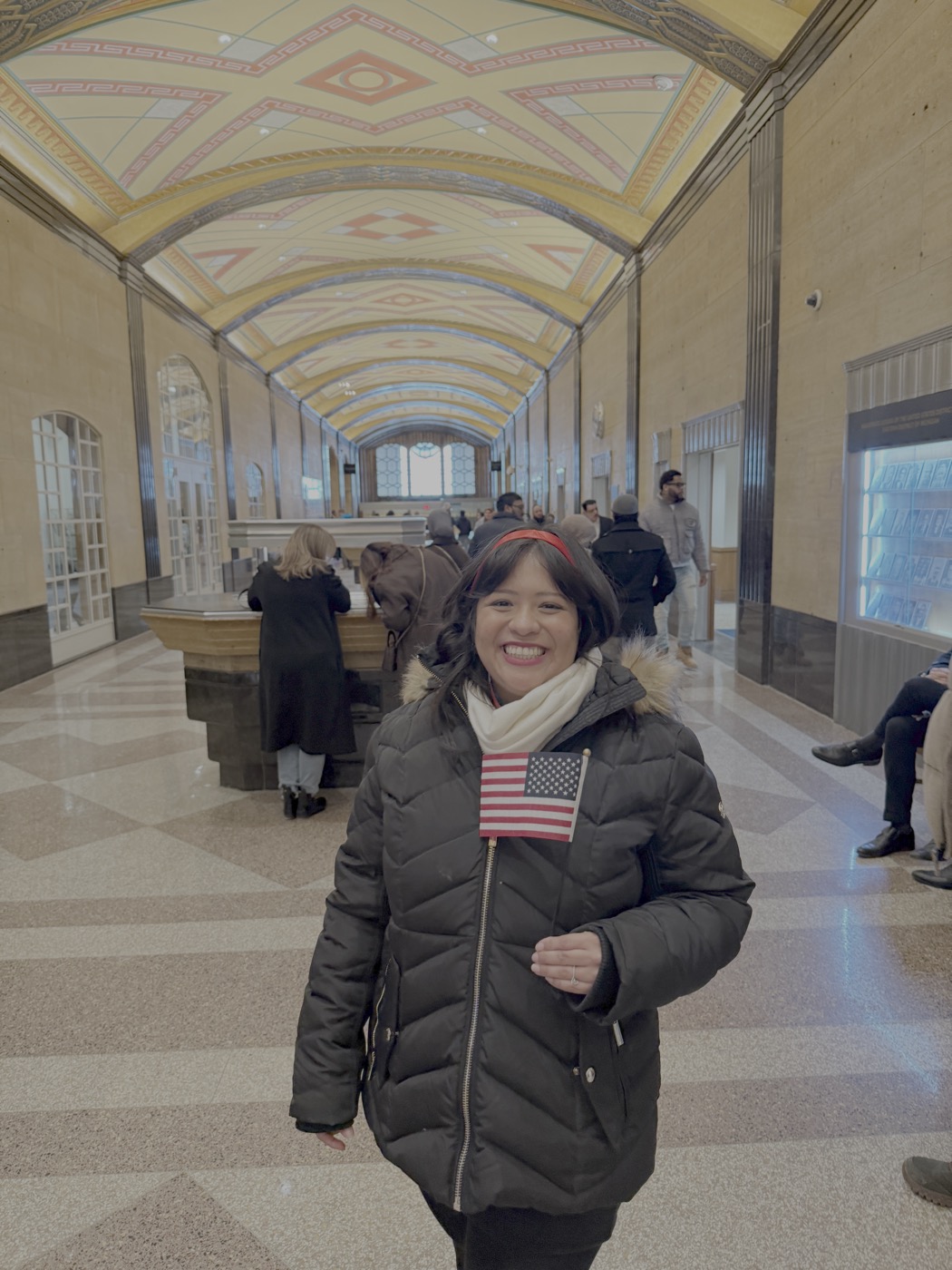 Myriam at her U.S. naturalization ceremony, holding an American flag